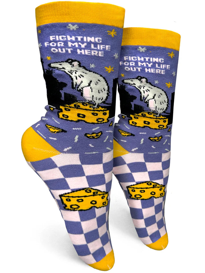 Foot forms wear purple crew socks with a checkerboard foot and NYC skyline on the ankle. A rat stands on a piece of cheese, and text reads