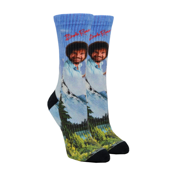 On footforms, a pair of blue crew socks featuring Bob Ross above a mountain landscape, with Bob's signature in red above his head.