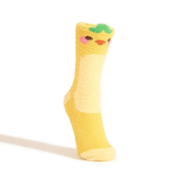 A fuzzy yellow crew sock fashioned to look like a duckling with a green leaf on its head is shown on a foot form against a white background.