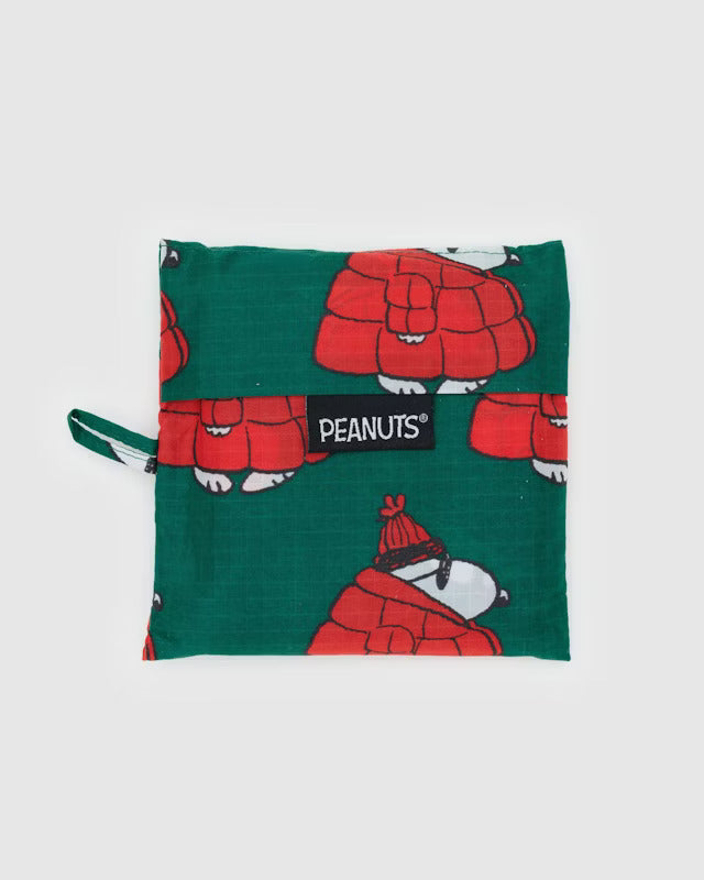 A forest green canvas pouch with several Snoopys walking as they wear sunglasses, red beanies and large red puffer coats. A back tag reads