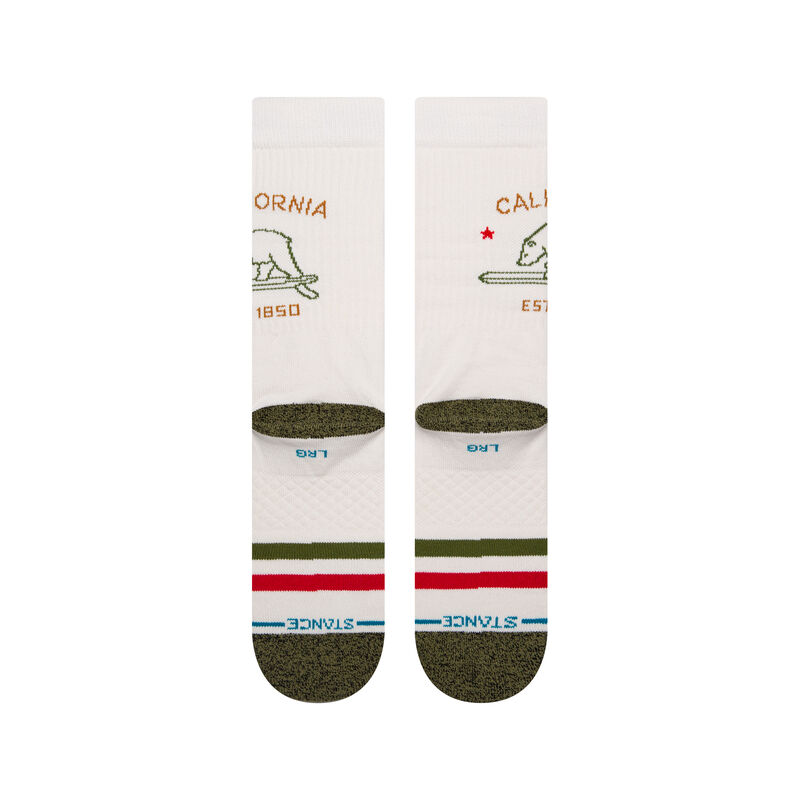 a flatlay of a pair of ivory socks with a green toe and red and green stripes on the ball of the foot with a minimal line drawing of the california bear in green with text above and below that reads california est. 1850