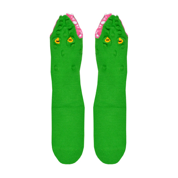 Shown in a flatlay, a pair of Foot Traffic, green cotton women's crew socks with three dimensional pattern of scaly alligator eating the foot