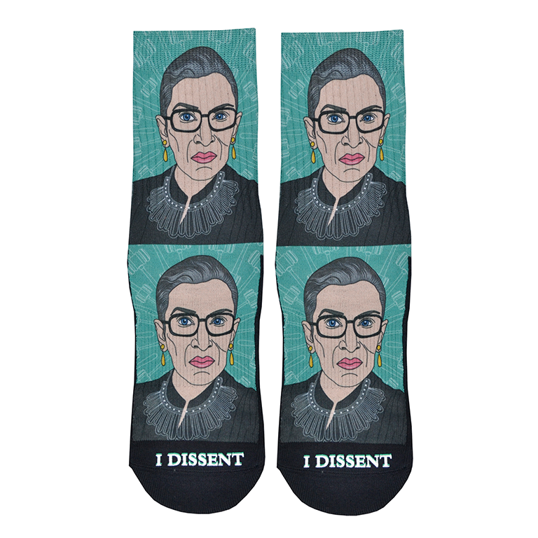 Shown in a flatlay, a pair of Good Luck Socks brand unisex green polyester and cotton crew socks. The front of these socks features a caricature of the iconic Supreme Court Justice Ruth Bader Ginsburg in one of her well-known collars with the words