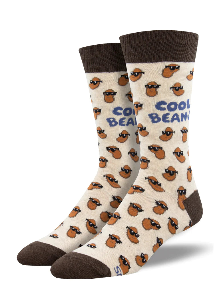 Shown on leg forms, a pair of Socksmith brand men's cotton crew socks in ivory with a brown heel, toe, and cuff. The sock features an all over motif of little brown beans in black sunglasses, the leg of the sock reads,