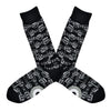 A black men's cotton crew sock by Modsock is shown on a flatlay featuring sheet music all along the sock from top to bottom.