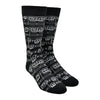 A black cotton Men's crew sock by Modsock is shown on a mannequin foot form featuring a sheet music design from its top to bottom.