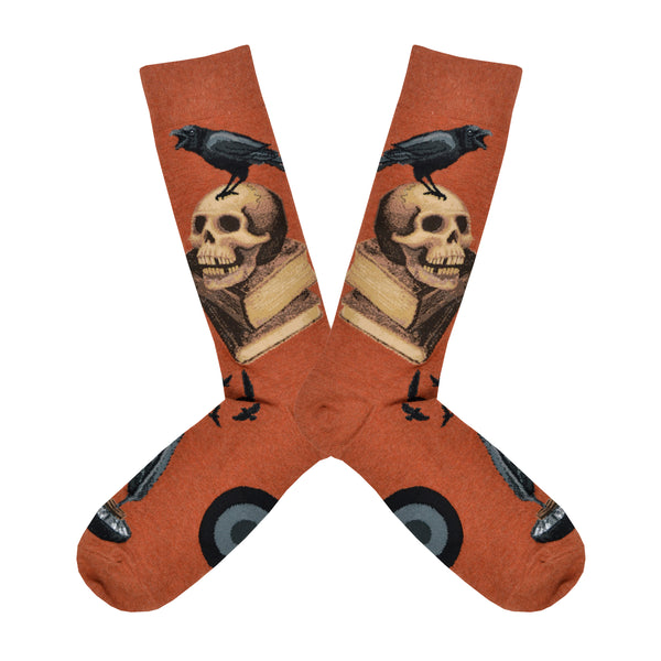 Shown in a flatlay, a pair of Mod Socks’ warm brown cotton men's crew socks with a stack of books, skull, and raven