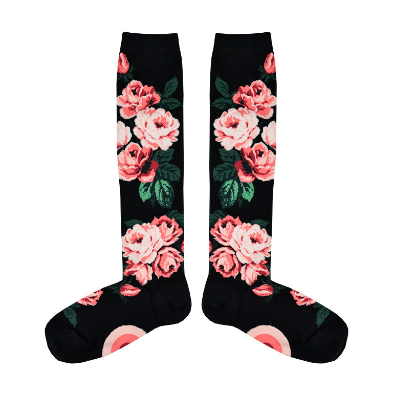 Flatlay image of black knee-high socks featuring pink roses