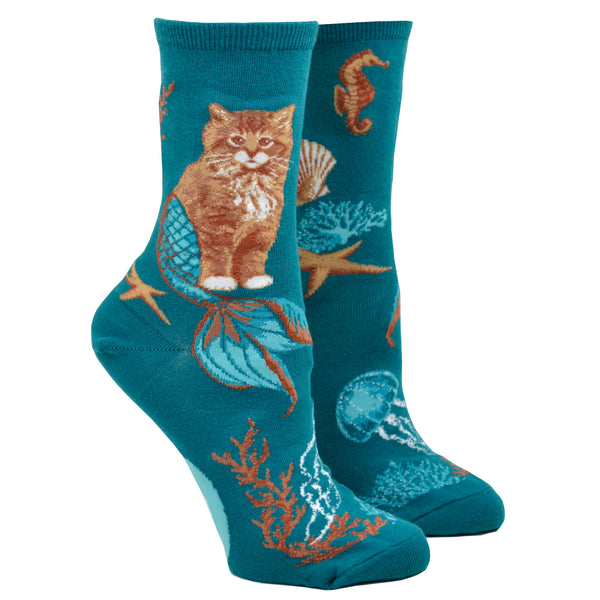 Turquoise socks with an image of a cat with a mermaid tail surrounded by coral and a sea star, photographed on a leg form.