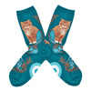 Turquoise socks with an image of a cat with a mermaid tail surrounded by coral and a sea star, photographed flat lay.