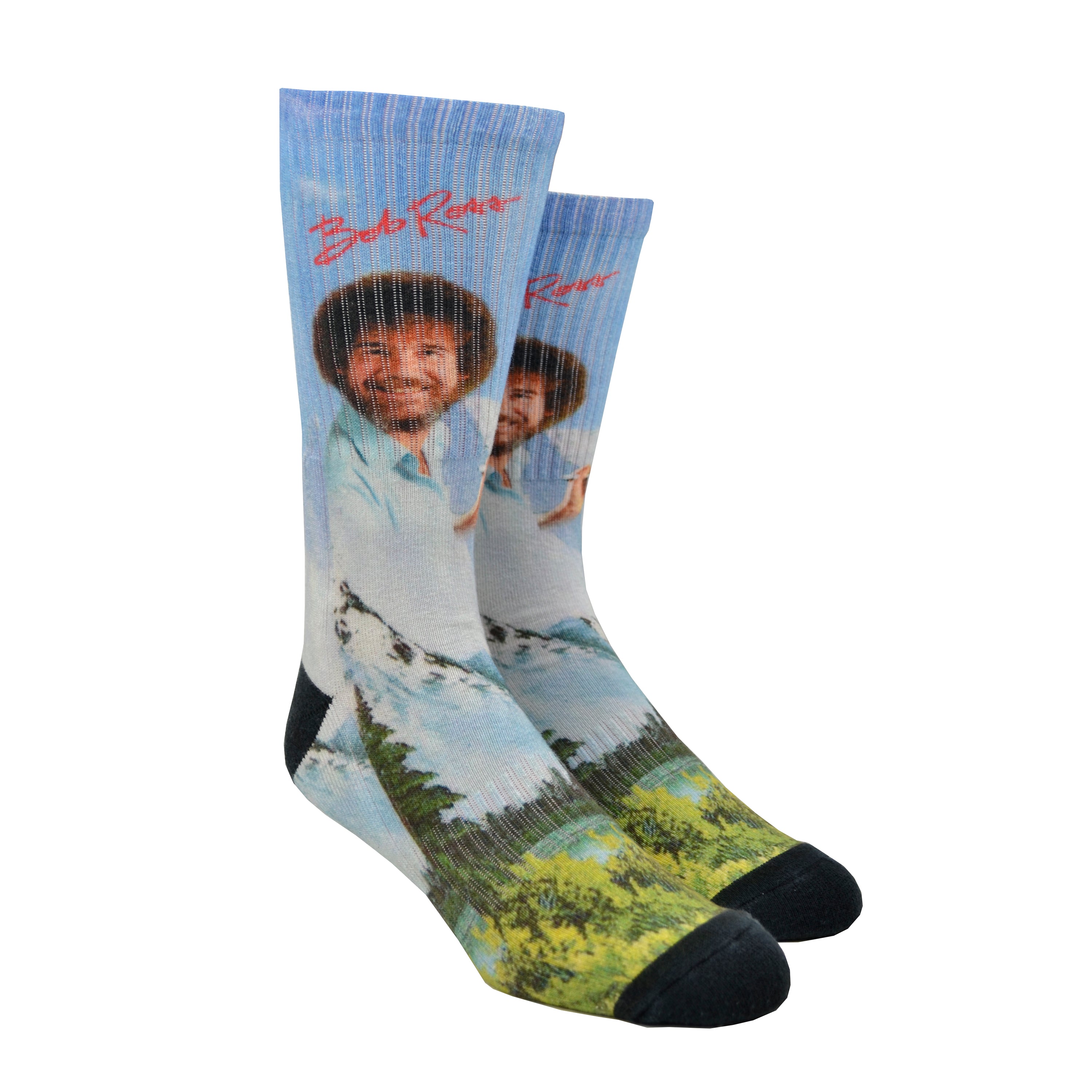 Shown on a leg form, a pair of Oooh Yeah’s cotton men’s crew socks with light blue nature-scape and Bob Ross portrait