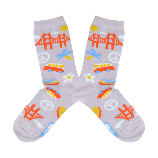 Shown in a flatlay, a pair of women's Yellow Owl Workshop cotton and nylon crew socks in lilac. These socks feature iconic San Francisco imagery like the golden gate bridge, peace signs, VW vans, seagull signage, and flower power.