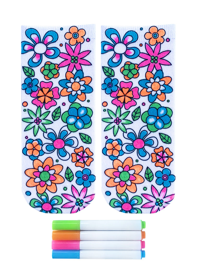 flatlay of floral coloring socks that have been colored with the four pictured neon fabric markers