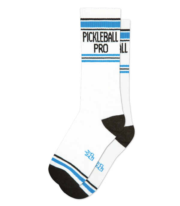 A blank background holds a pair of white socks in flatlay that have black toes and heels, blue and black stripe patterns near the toe and ankle, and "PICKLEBALL PRO" in black lettering