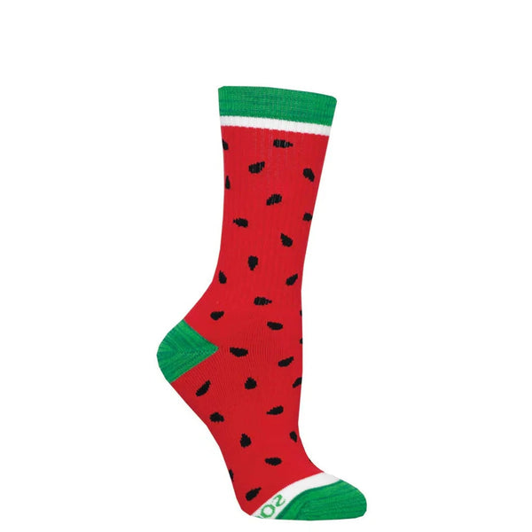 A footform holds a red sock designed like a watermelon with green toe, ankle and heel and scattered black seeds 