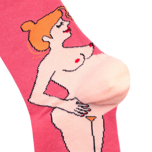 Closeup of a pink sock with a redheaded pregnant white woman whose bump is the heel of the sock