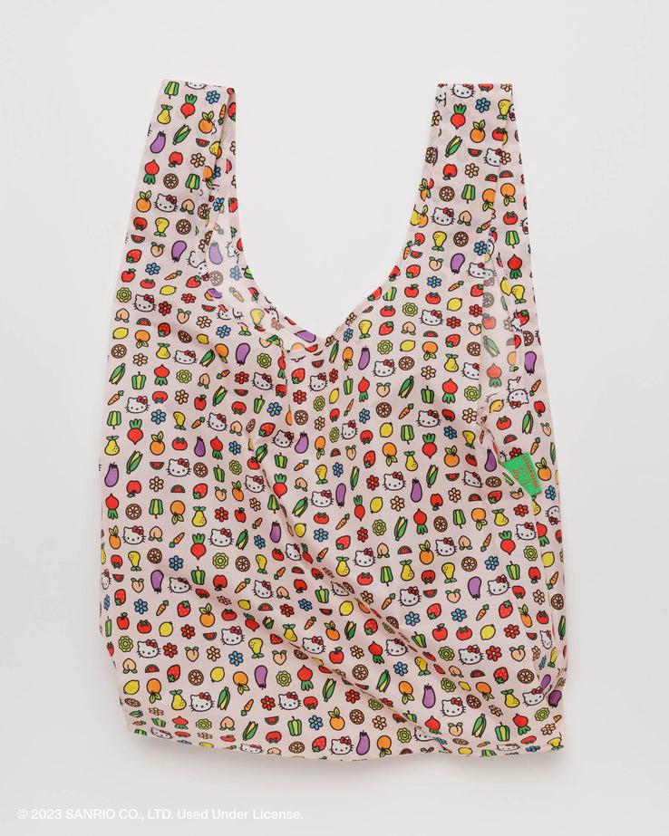 a reusable nylon shopping bag printed with a motif of small hello kitty face illustrations and comic-book style fruit and flowers
