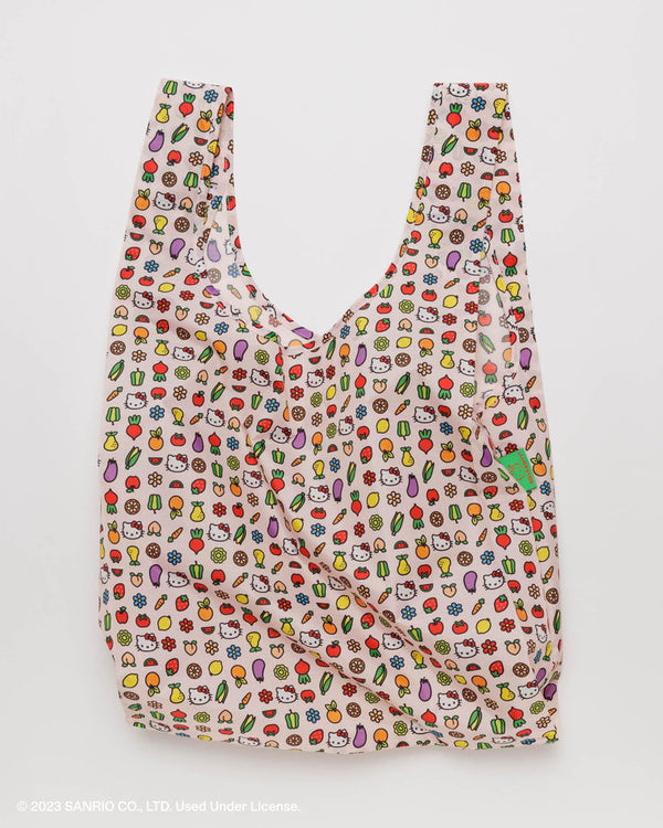 a reusable nylon shopping bag printed with a motif of small hello kitty face illustrations and comic-book style fruit and flowers