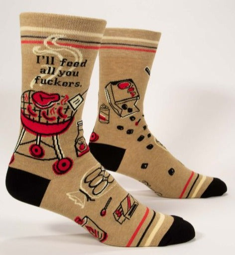 a pair of beige socks with a black toe and heel, and a simple colorful drawing of a barbeque topped with a steak and sausages and the text 