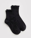 A pair of black ribbed ankle socks with matching black ruffled trim at the top, displayed on a white background.