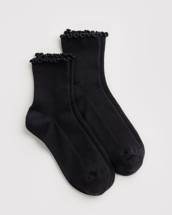 A pair of black ribbed ankle socks with matching black ruffled trim at the top, displayed on a white background.