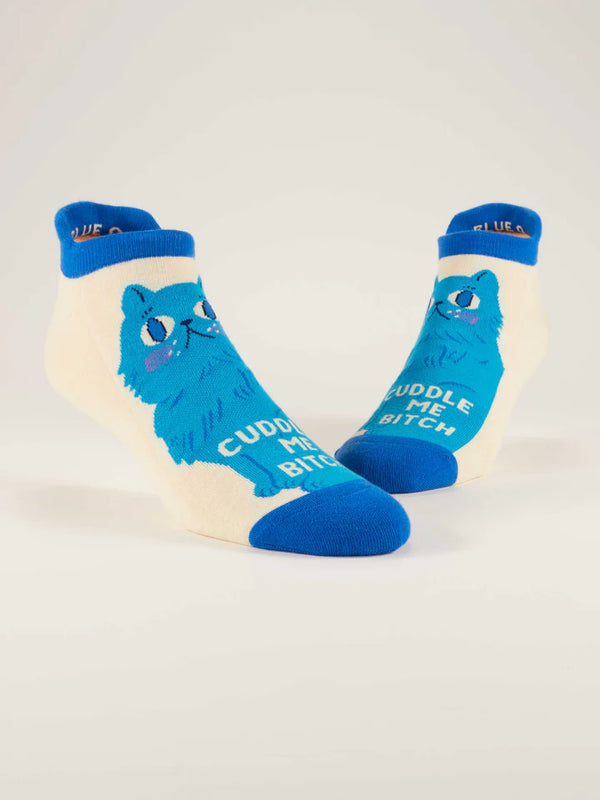 Pair of cream-colored ankle socks featuring a blue cat and text that reads "CUDDLE ME BITCH"