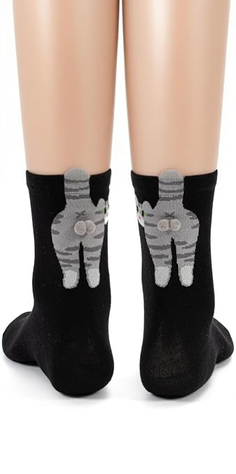 Model wears black socks featuring gray cats with fuzzy gray pompom balls