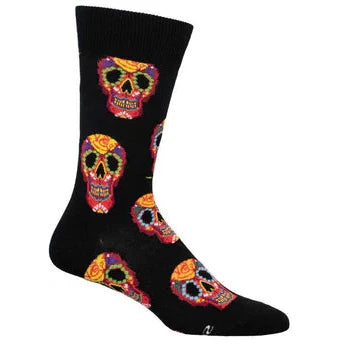 A footform wears a black crew sock featuring red skulls with yellow, green, blue and white designs painted on them