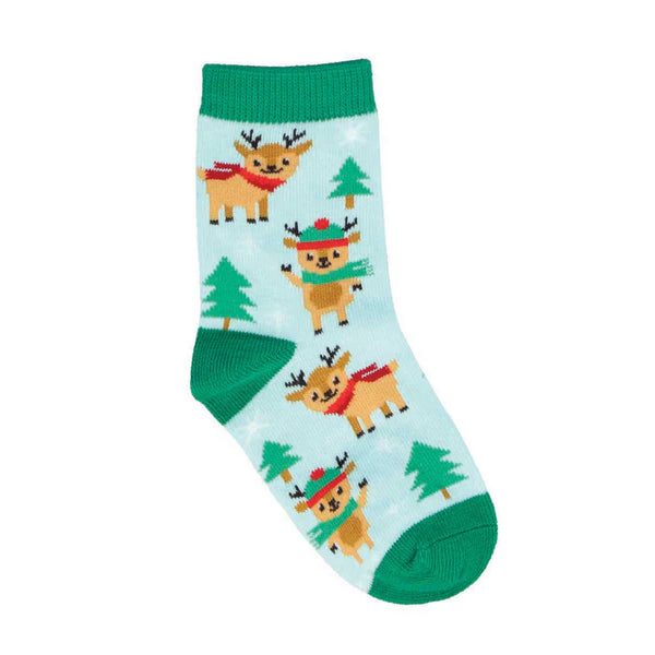 Light blue children's sock in flatlay featuring evergreen trees and smiling reindeer in hats and scarves