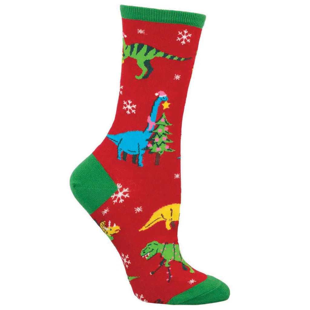 A footform displays a red crew sock with green ankle, heel and toe that features snowflakes and dinosaurs engaged in holiday activities.