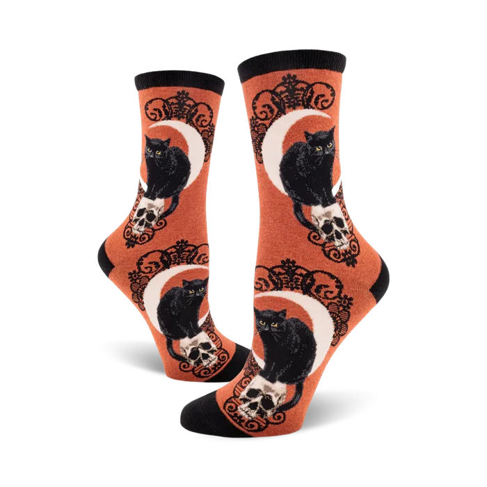 Pair of socks with black cat, skull and moon design on an orange background
