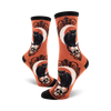 Pair of socks with black cat, skull and moon design on an orange background
