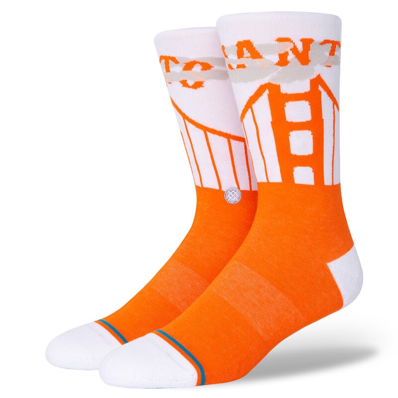 Two foot forms wear socks with white leg, heel & toe and orange feet. The leg sports gray fog, an orange depiction of the Golden Gate Bridge, and orange text that reads 