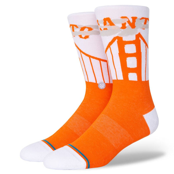 Two foot forms wear socks with white leg, heel & toe and orange feet. The leg sports gray fog, an orange depiction of the Golden Gate Bridge, and orange text that reads "GIANTS."