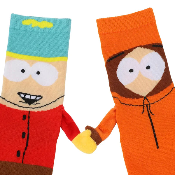 Close-up of 2 socks in flatlay, one made to look like Cartman and the other Kenny, with 3D arms and magnetic hands