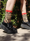 Model wears chunky black shoes and leopard print socks that read "Feeling a little cunty today"