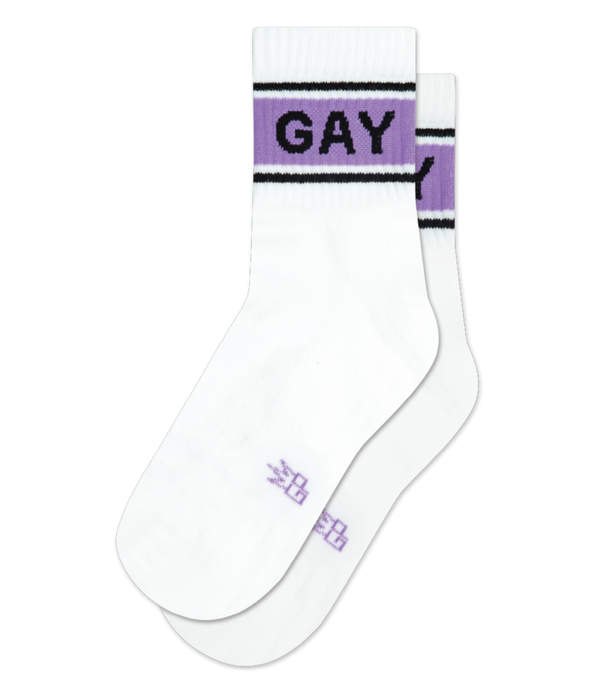 a pair of white, quarter length socks with purple and black stripes on the cuff and bold black text that says GAY