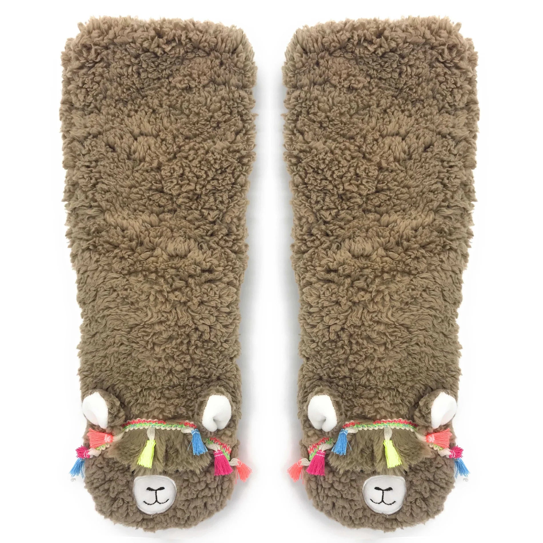 In flatlay: pair of fuzzy socks designed to look like llamas wearing tasseled headbands
