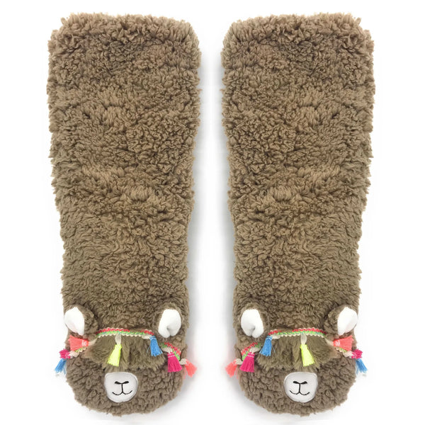 In flatlay: pair of fuzzy socks designed to look like llamas wearing tasseled headbands