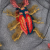 Embroidered yellow & orange beetle on a sheer black background