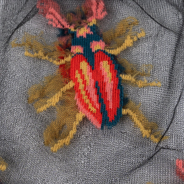 Embroidered yellow & orange beetle on a sheer black background