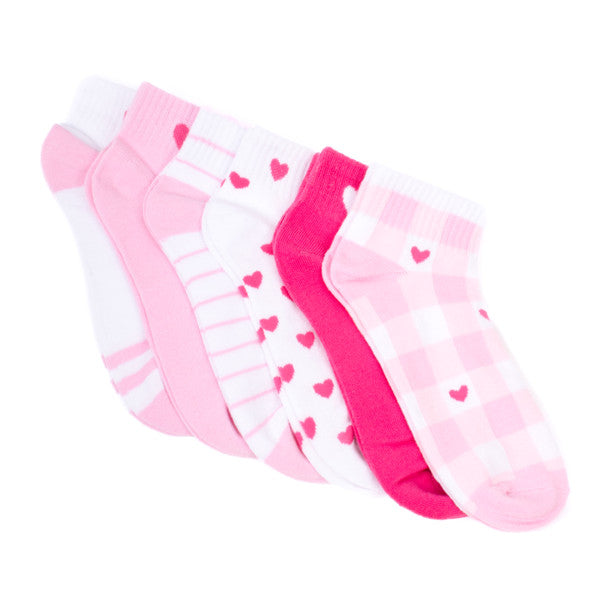 A white background displays six quarter-crew length socks in flatlay: pink and white plaid with hot pink hearts, solid pink with a hot pink heart on the ankle, solid hot pink with a light pink heart on the ankle, white with hot pink hearts all over, white with pink stripes, and white with pink stripe patterns on the toe and a pink heart on the ankle