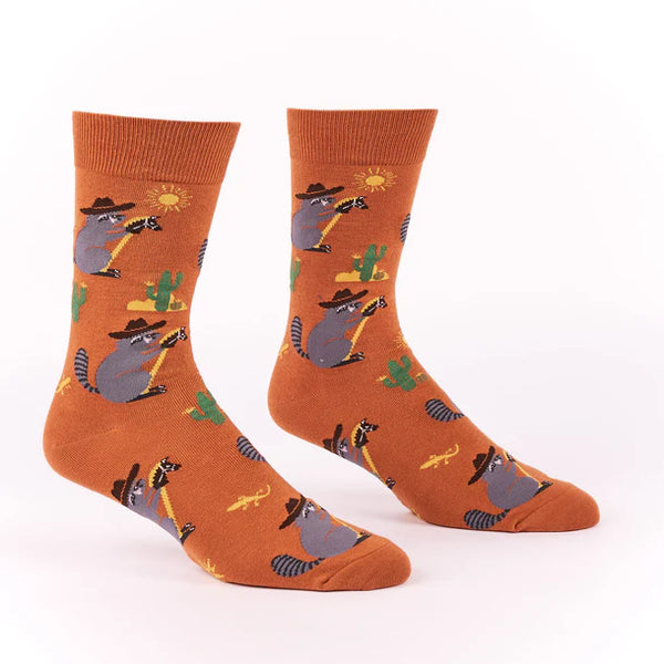 Foot forms wear brown socks featuring raccoons wearing cowboy hats riding hobby horses through a desert scene