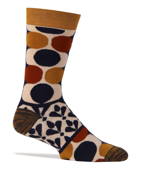 Foot form wears a crew sock featuring a geometric 60's mod pattern in gold, burnt orange, navy and ivory.