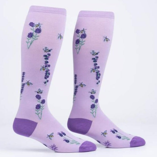 a pair of light purple knee high socks with a darker purple toe and heel covered in small purple flowers, green stems and small bees