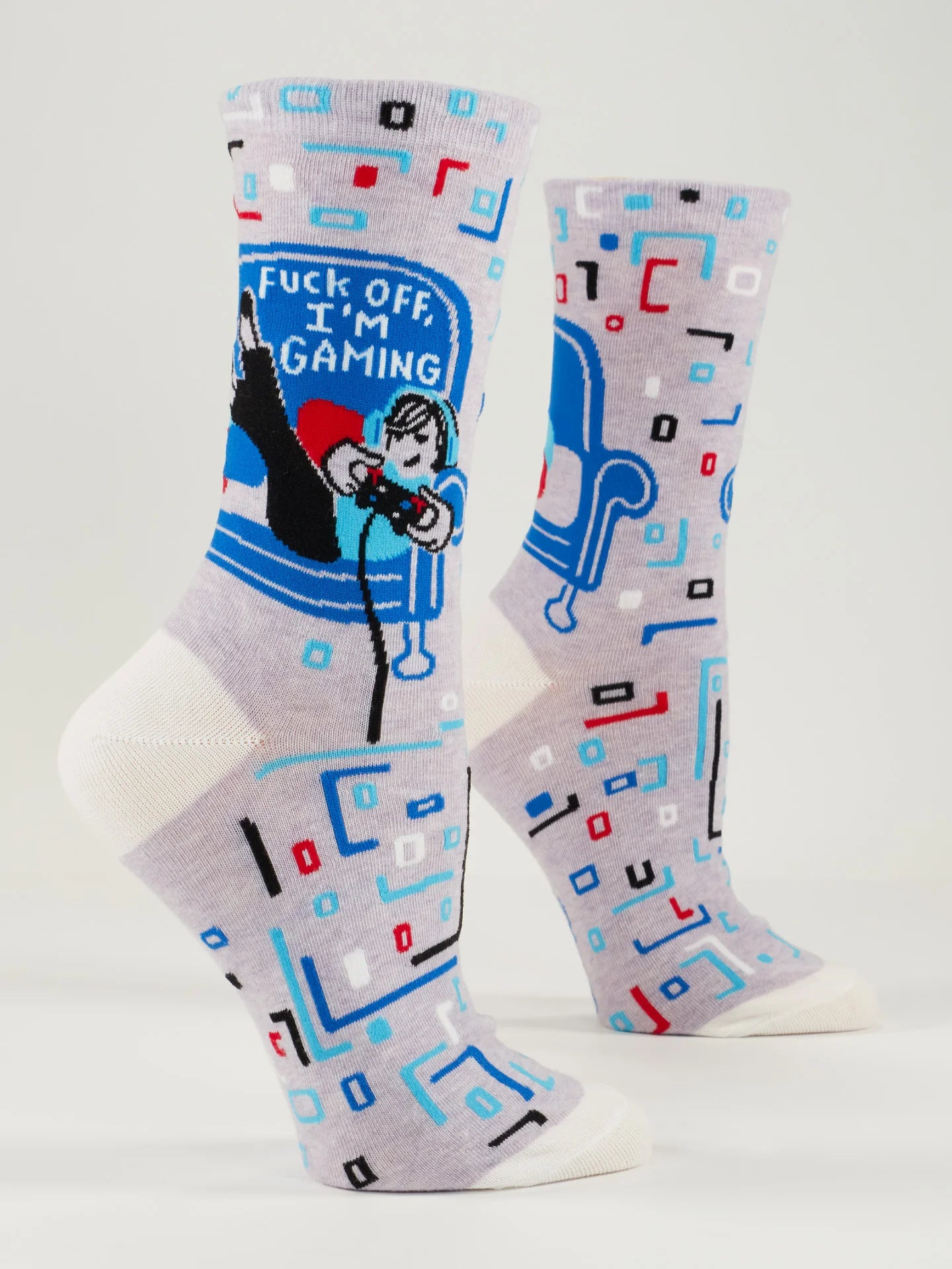 2 foot forms wear lavender socks with white heel, toe and top. They feature boxy red, blue, black, white and aqua designs, and a woman in an aqua hoodie on a blue couch with a video game controller. White text on the couch reads 