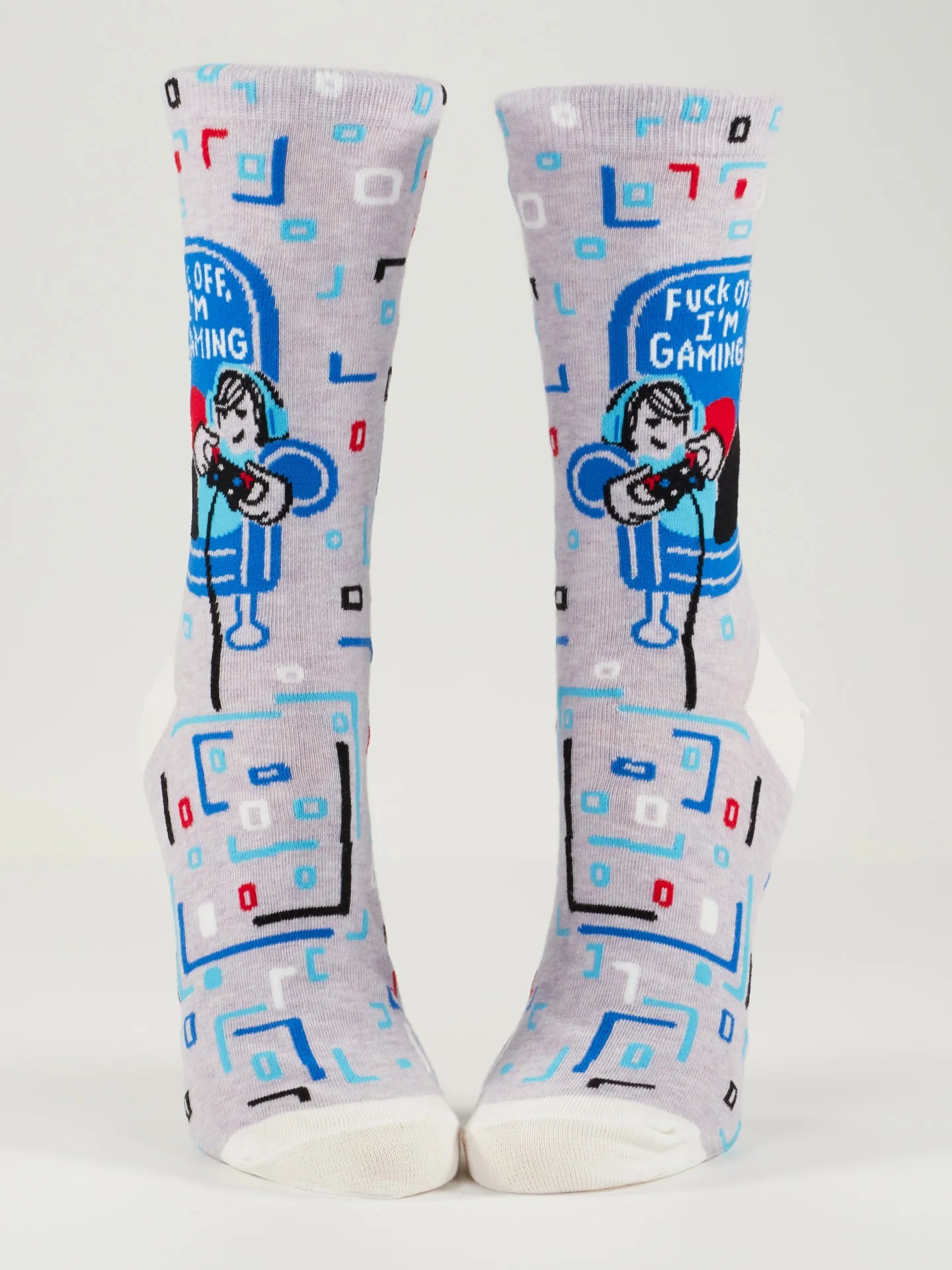 2 foot forms wear lavender socks with white heel, toe and top. They feature boxy red, blue, black, white and aqua designs, and a woman in an aqua hoodie on a blue couch with a video game controller. White text on the couch reads 