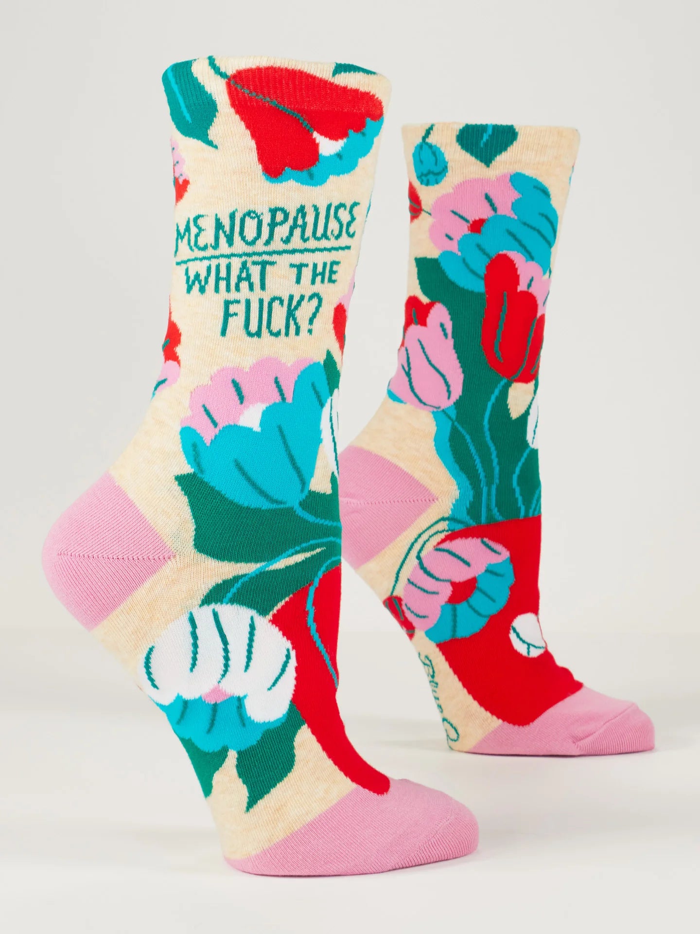 2 foot forms wear beige socks with pink heel & toe featuring a bouquet of white, blue, pink and red flowers with green leaves in a red pot. Green text reads 