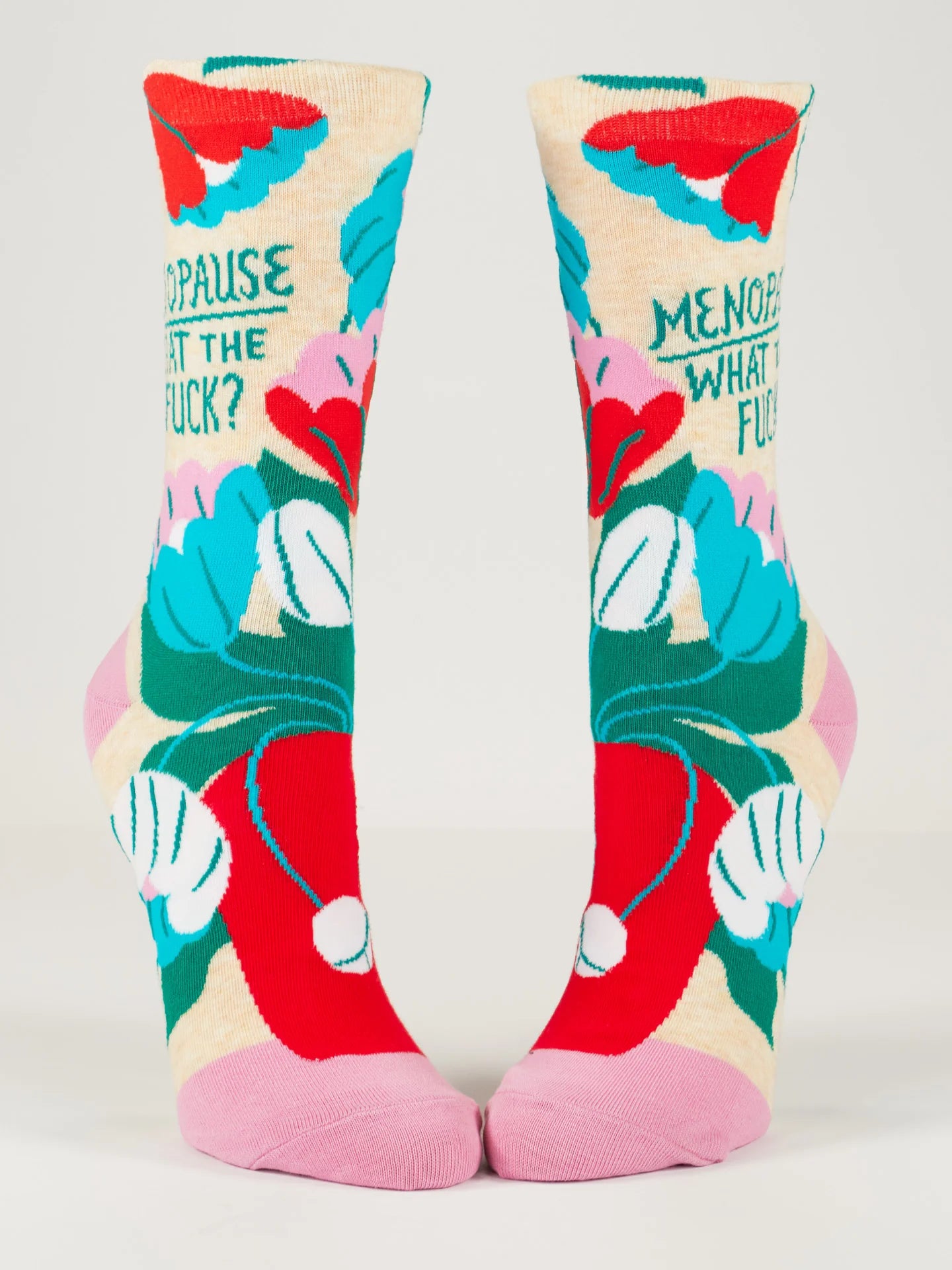 From the front, 2 foot forms wear beige socks with pink heel & toe featuring a bouquet of white, blue, pink and red flowers with green leaves in a red pot. Green text reads 