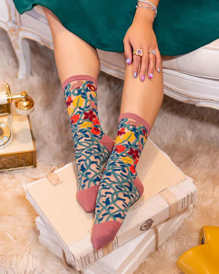 Model wears sheer socks featuring a teal vine design with orange, gold, red & mauve flowers & birds
